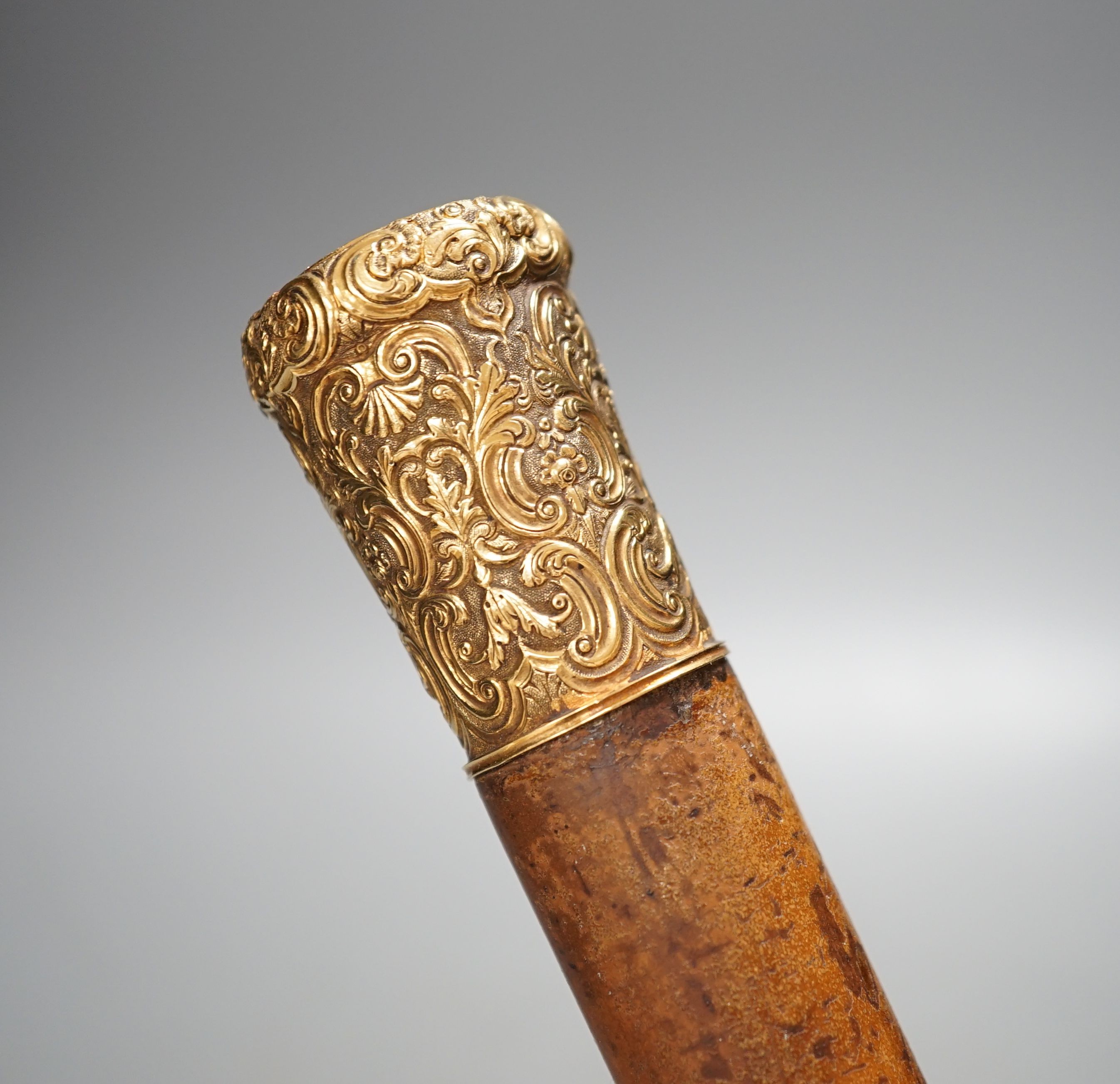 A 19th century malacca walking cane, with embossed yellow metal mount, 95cm.